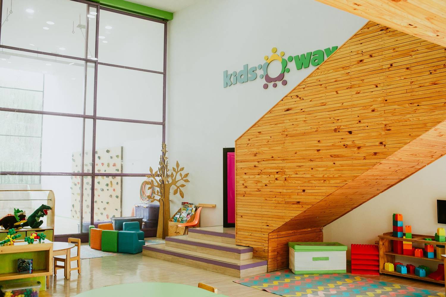 Hall central de doble altura con escalera de madera